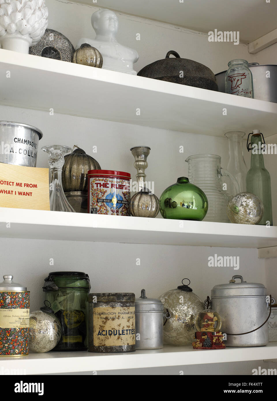 Dekoration für Weihnachten, Regale aus einem Schrank mit Objekten, Dosen, Flaschen, Obst, dekoriert. Dosen, Töpfe, Kerze Stockfoto