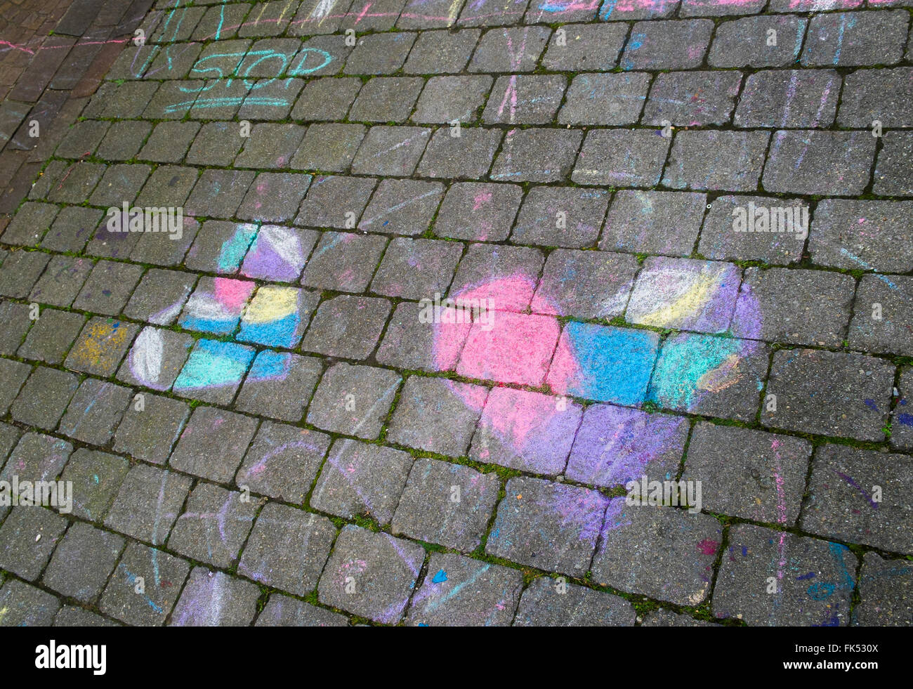farbige Kreidezeichnung zeigt zwei Herzen und dem Wort stop Stockfoto