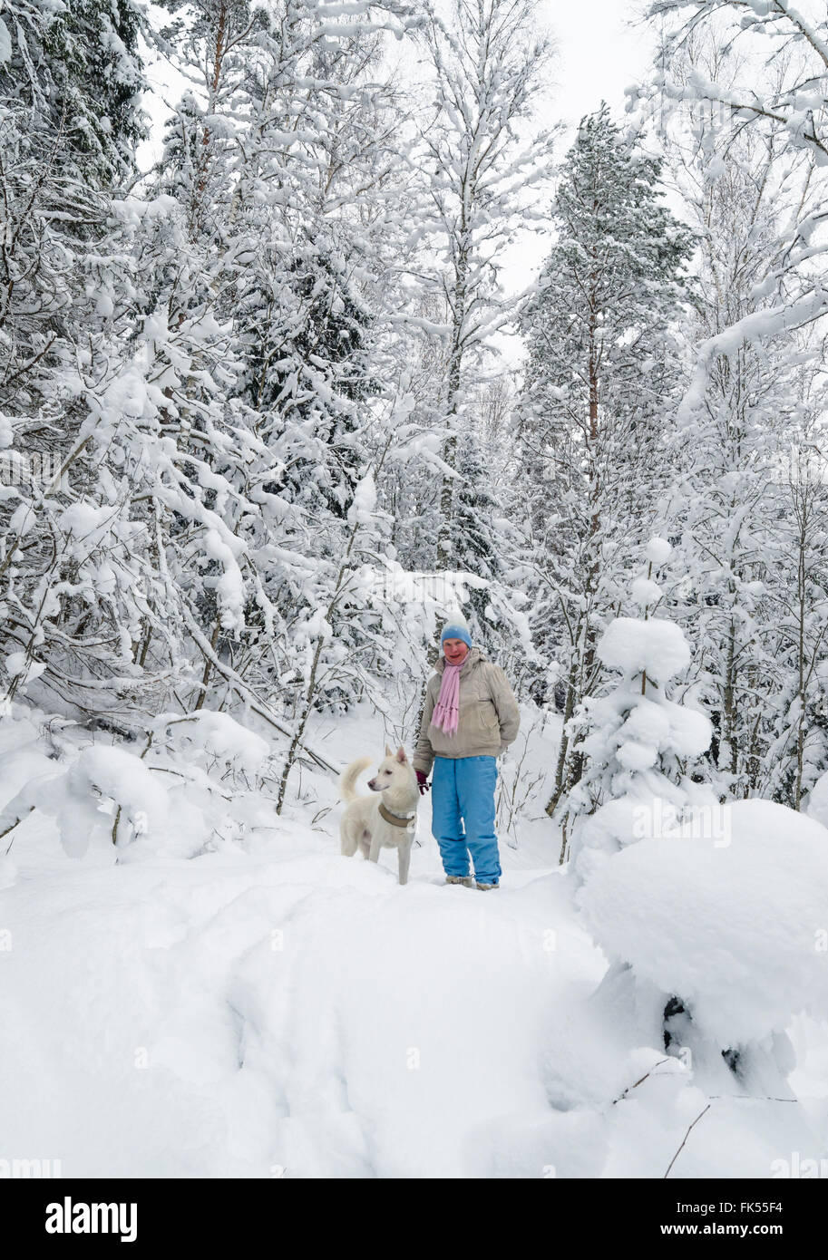 Die Frau mit einem Hund auf Spaziergang im Wald winter Stockfoto