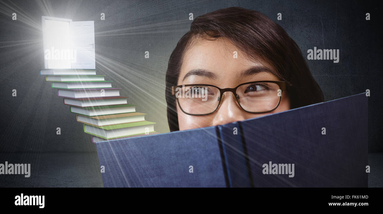 Zusammengesetztes Bild hübsche Studentin Gesicht hinter einem Buch versteckt Stockfoto