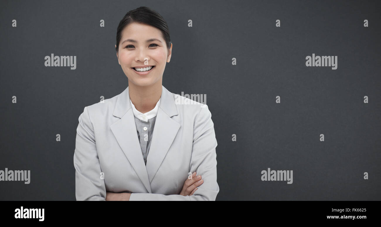 Zusammengesetztes Bild des lächelnden Geschäftsfrau mit verschränkten Armen Stockfoto