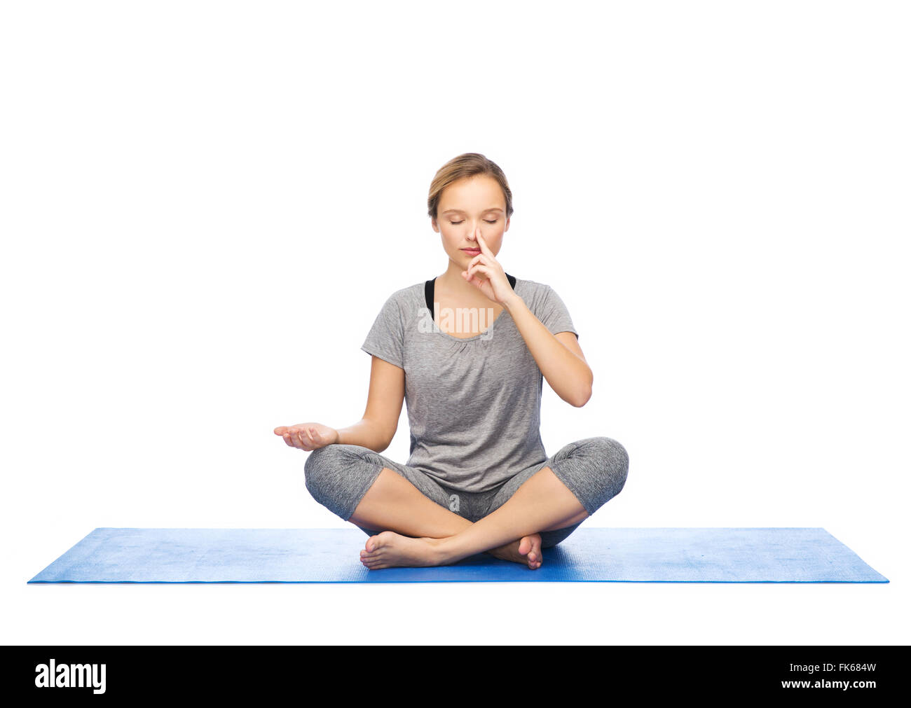 Frau macht Yoga Meditation in Lotus Pose auf Matte Stockfoto