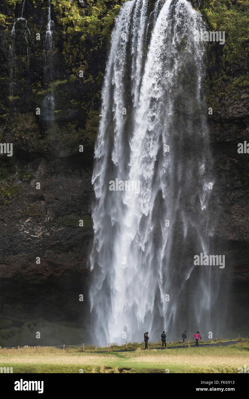 Touristen am Seljalandsfoss, einem berühmten Wasserfall direkt an der Route 1 in Süd-Island (Sudurland), Island, Polarregionen Stockfoto