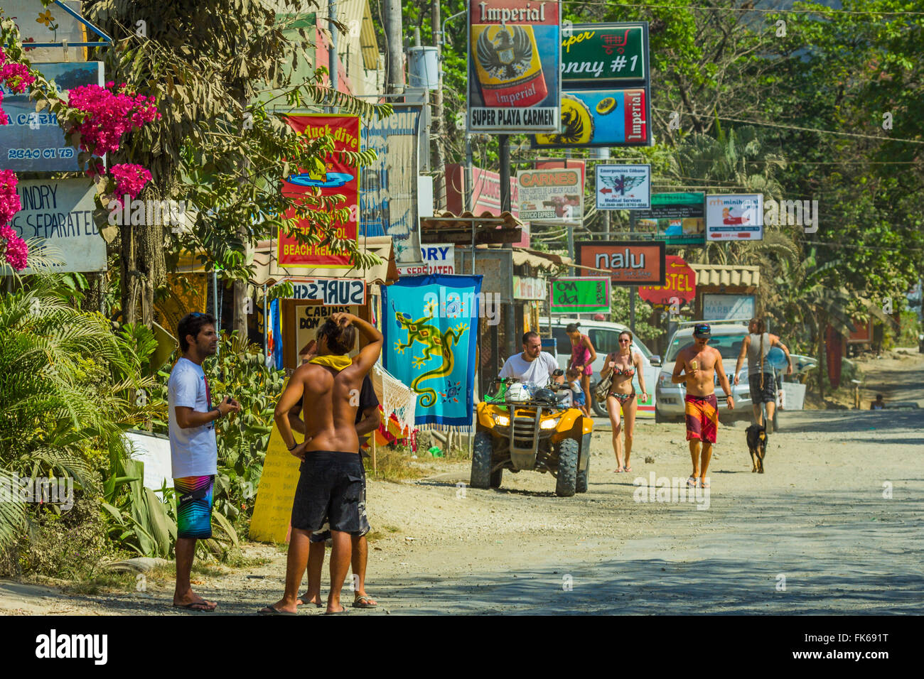 Touristen und Zeichen auf der Hauptstraße in diesem geschäftigen Süd Küste von Nicoya Halbinsel Resort in Santa Teresa, Puntarenas, Costa Rica Stockfoto