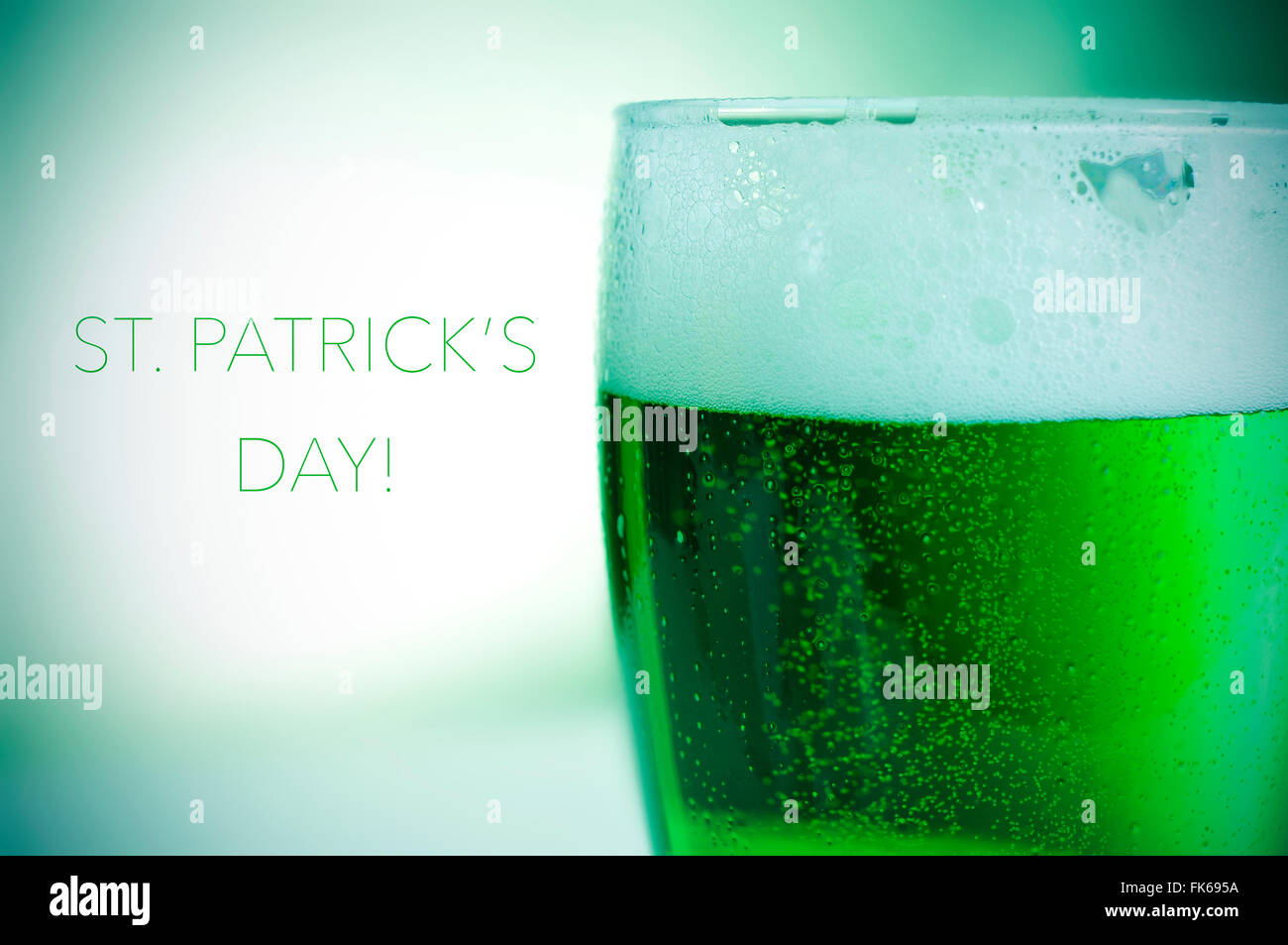 Nahaufnahme eines Glases mit gefärbten Jungbier und den Text glücklich St. Patricks day Stockfoto