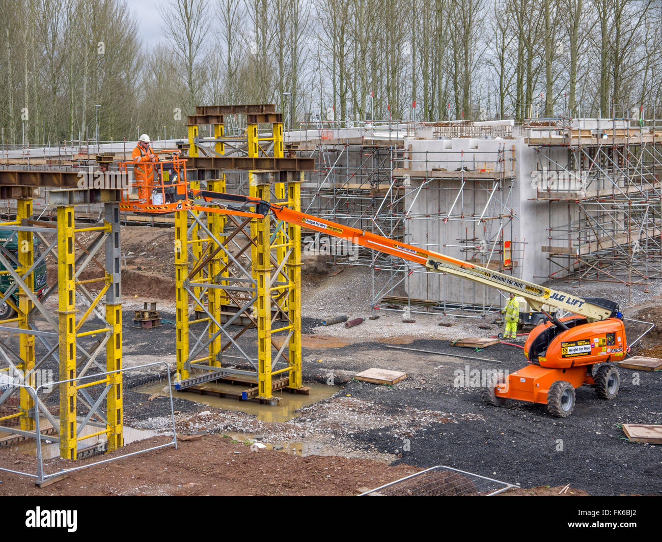 Bau Mann errichten Brücke Stelzen für eine neue Fußgängerbrücke an der Spitze gesenkt werden. Stockfoto