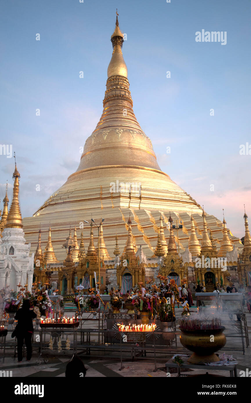 Kerzen von Anhängern bei Sonnenuntergang vor der goldenen Shwesagon-Pagode, eine 2500 Jahre alte buddhistische Pilgerstätte, Yangon gelegt Stockfoto