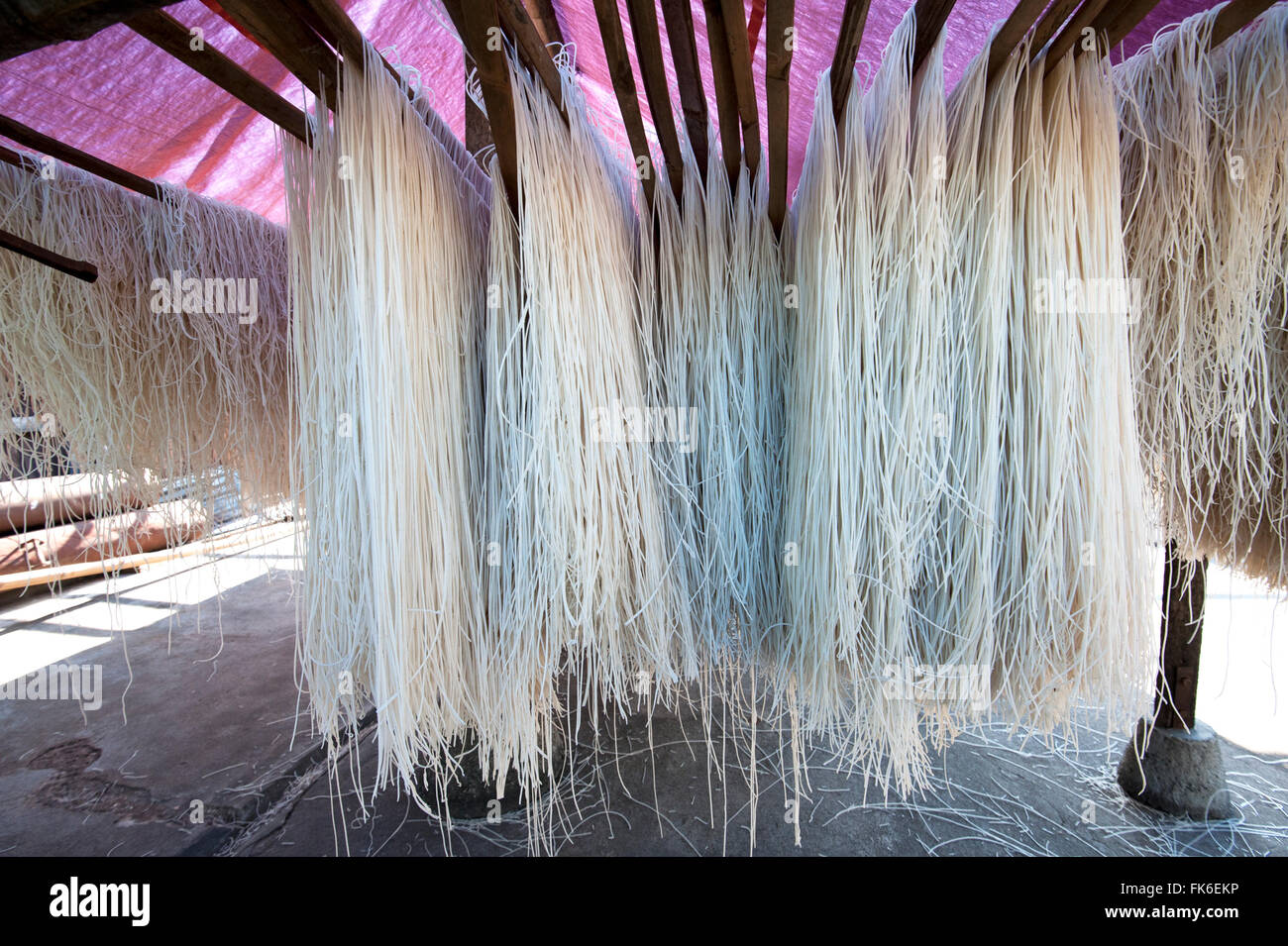 Frisch zubereitete Reisnudeln über Bambus-Stangen zum Trocknen hängen, bereit für den Verkauf, Hsipaw, Shan-Staat, Myanmar (Burma), Asien Stockfoto