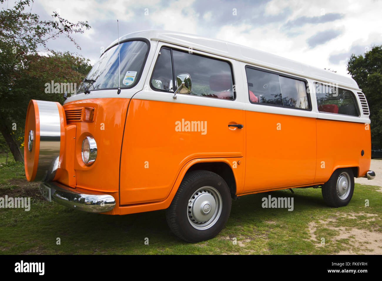 Volkswagen Camper van hell Orange und weiß in neuwertigem Zustand wie neu. Weißes Top und orange Körper mit Chrom-Stoßstangen und Reserverad Träger auf Vorderseite Stockfoto