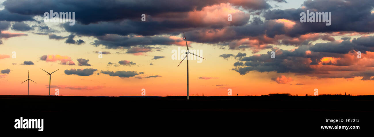 Ökostrom, Windkraftanlagen in orange sunset panorama Stockfoto