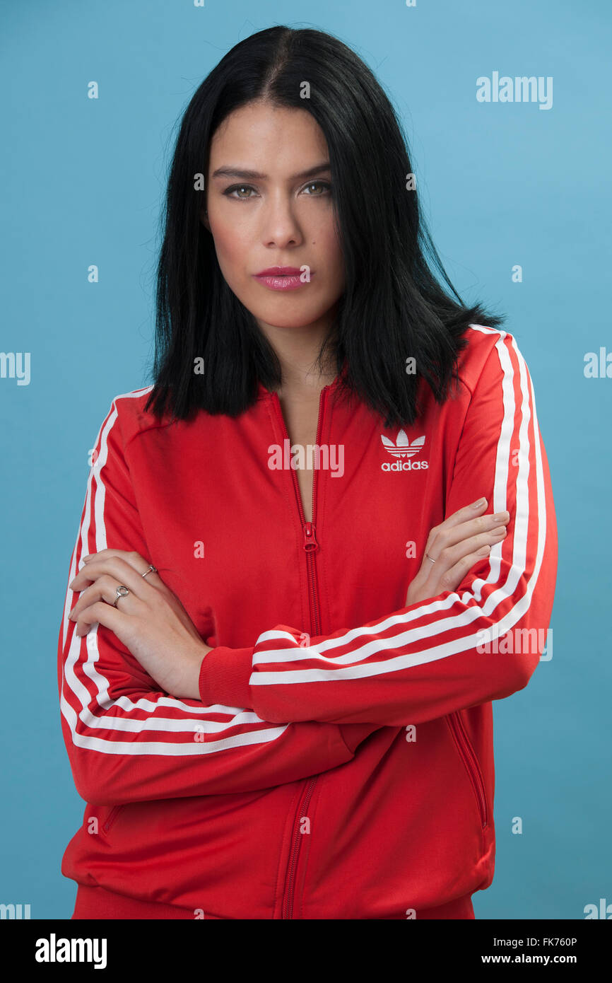 Weibliches Model trägt eine rote Retro-Adidas Zip Jacke Stockfoto