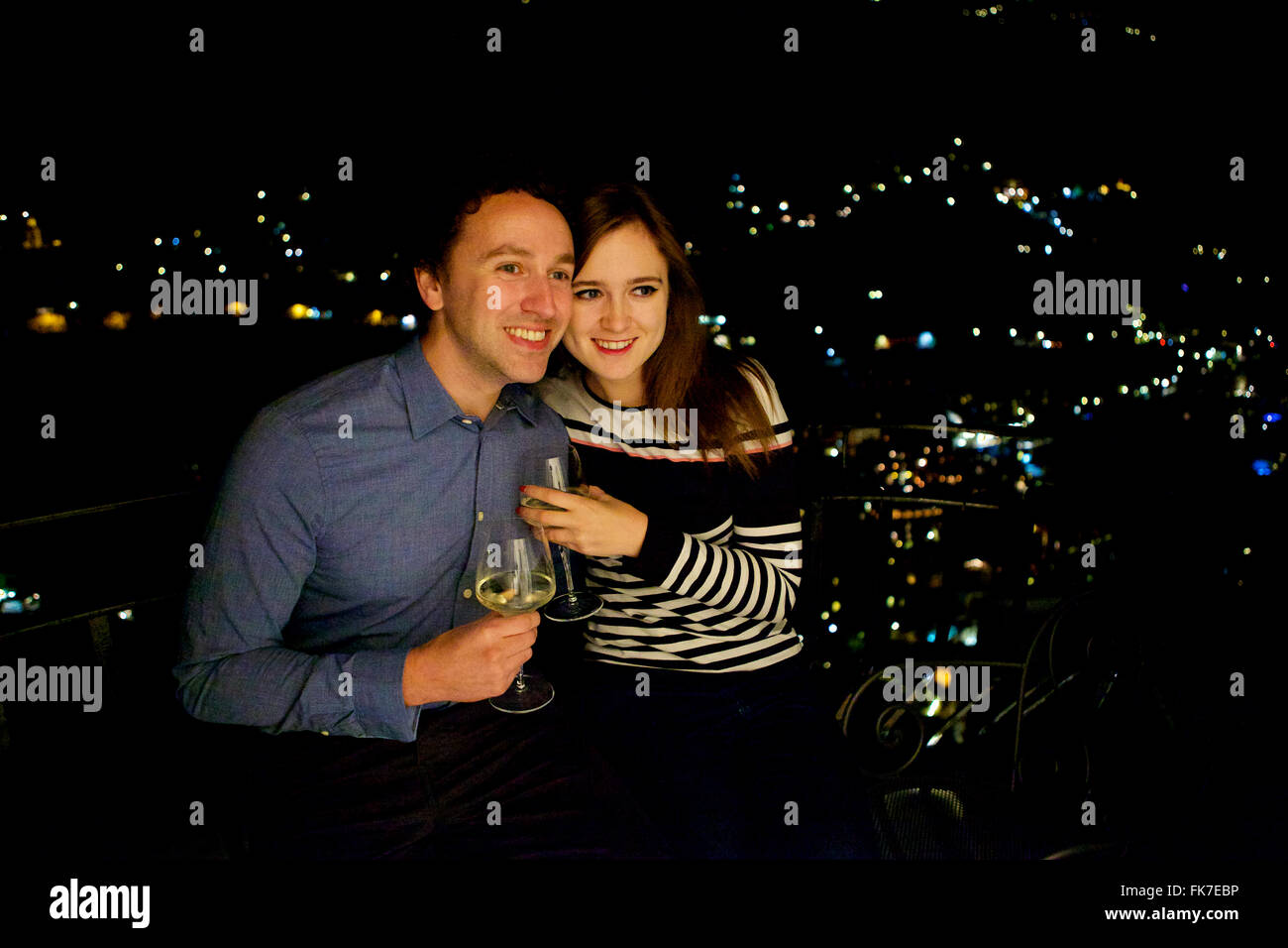 Jung und in der Liebe feiert Brünette Pärchen im Urlaub in Italien, Amalfi-Küste, mit einem Drink auf dem Balkon in der Nacht Stockfoto