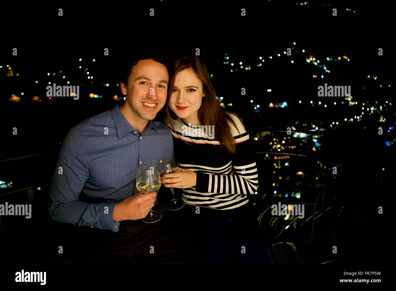 Jung und in der Liebe feiert Brünette Pärchen im Urlaub in Italien, Amalfi-Küste, mit einem Drink auf dem Balkon in der Nacht Stockfoto