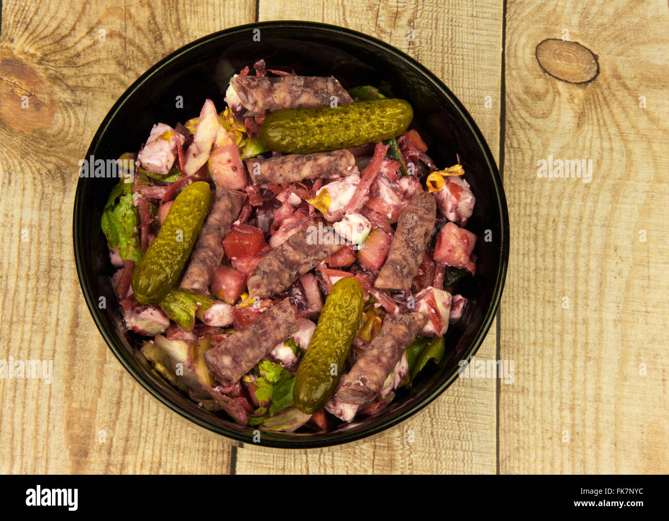 Schwarze Schale mit Salat-Mix mit Rüben, Feta-Käse, Paprika, dünne Wurst und Gurken auf hölzernen Hintergrund. Horizontale Ansicht her Stockfoto