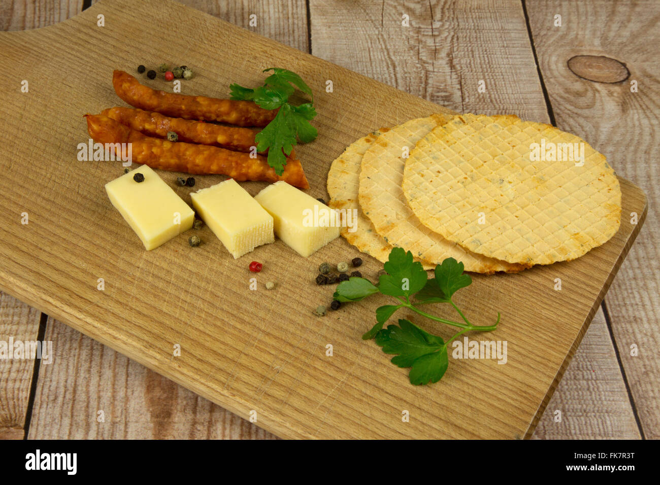 TARCZYŃSKI, dünne Wurst, Käse und Wafer auf eine hölzerne Arbeitsplatte, geschmückt mit Petersilie und Pfeffer Körner gefärbt. Horizontale Ansicht f Stockfoto