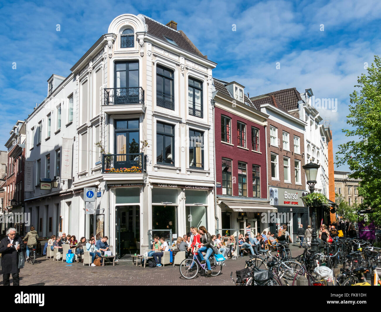 Straßenszene mit Menschen auf der Außenterrasse und Fahrräder auf Oudegracht in Stadt Utrecht, Niederlande Stockfoto