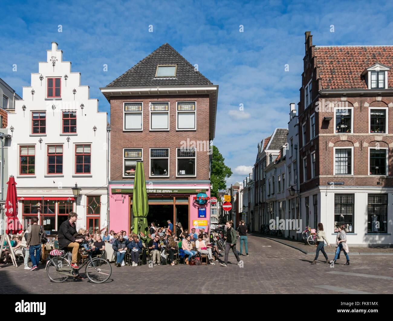 Menschen auf der Außenterrasse und Radfahrer auf Korte Minrebroederstraat - Stadtleben in Utrecht, Niederlande Stockfoto