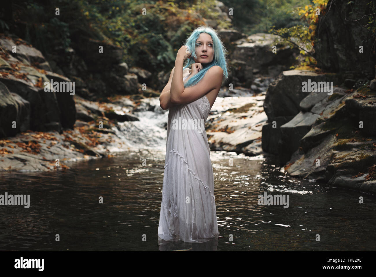 Ätherische Frau posiert im Bergbach. Romantik und Fantasie Stockfoto