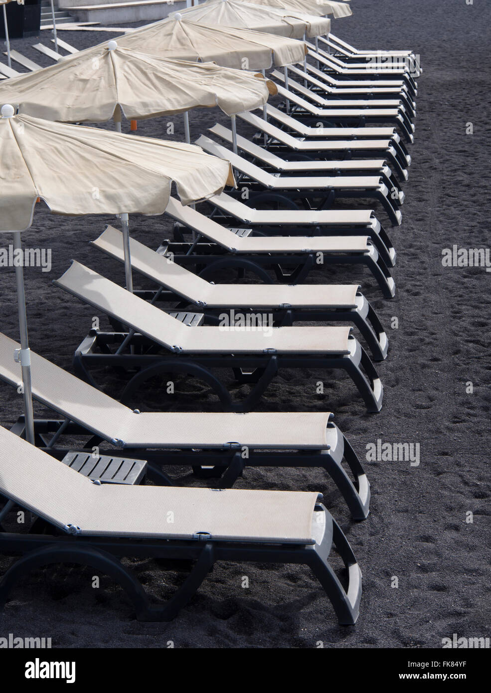 Weiße leere Liegestühle am schwarzen vulkanischen Lava Sand, am frühen Morgen in Alcala Teneriffa-Kanarische Inseln-Spanien Stockfoto