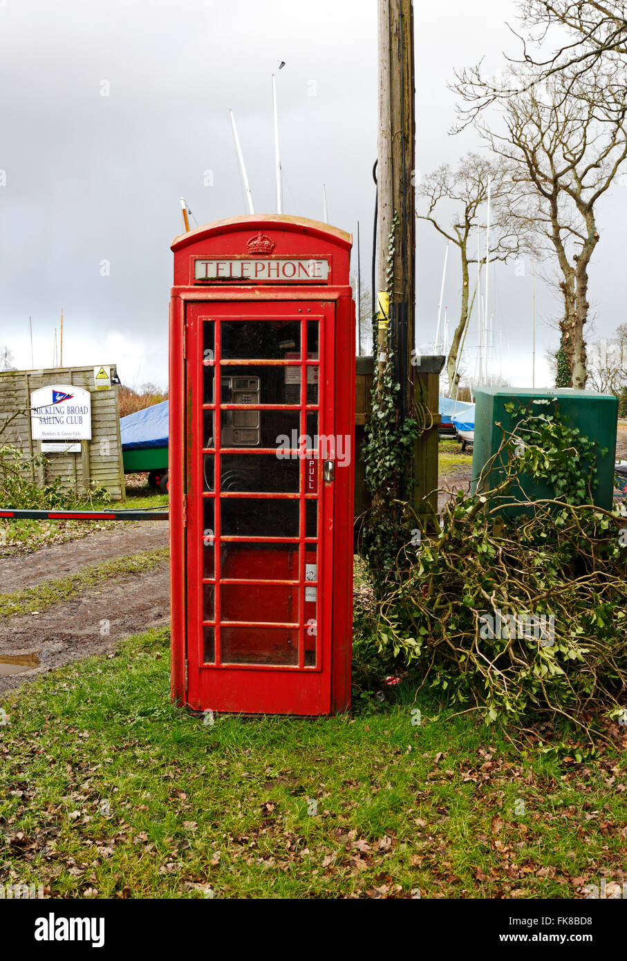 Eine alte rote Telefonanruf Formatfeld mit Vergnügen Boot Dyke auf den Norfolk Broads in Hickling, Norfolk, England, Vereinigtes Königreich. Stockfoto