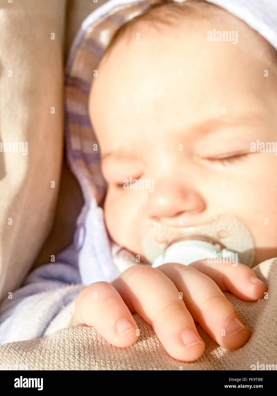 5 Monate Baby schläft seelenruhig unter den Sonnenstrahlen Stockfoto