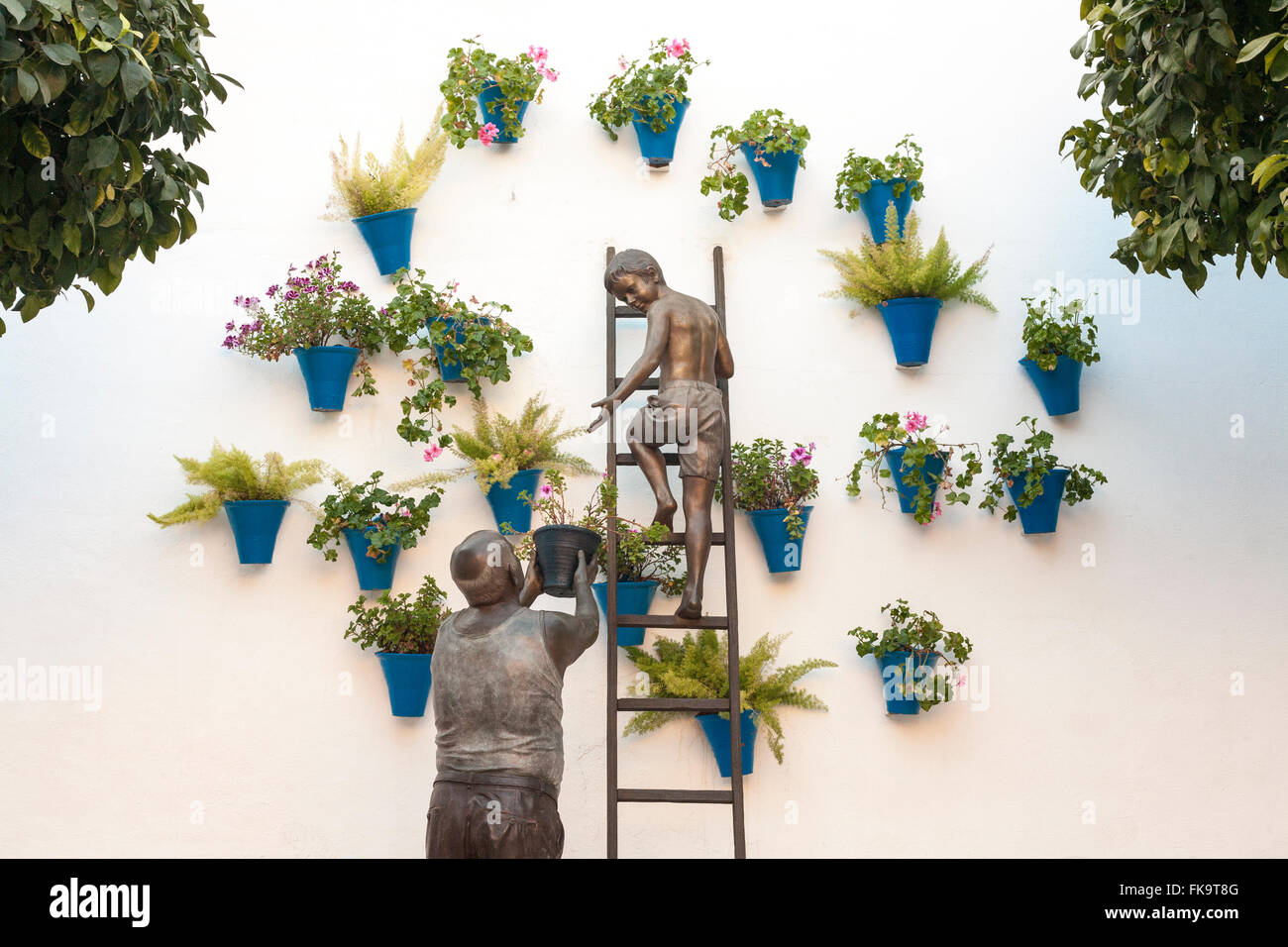 Skulpturenensembles repräsentieren eine Oma und Enkel Blumentöpfe an der Wand platzieren Stockfoto