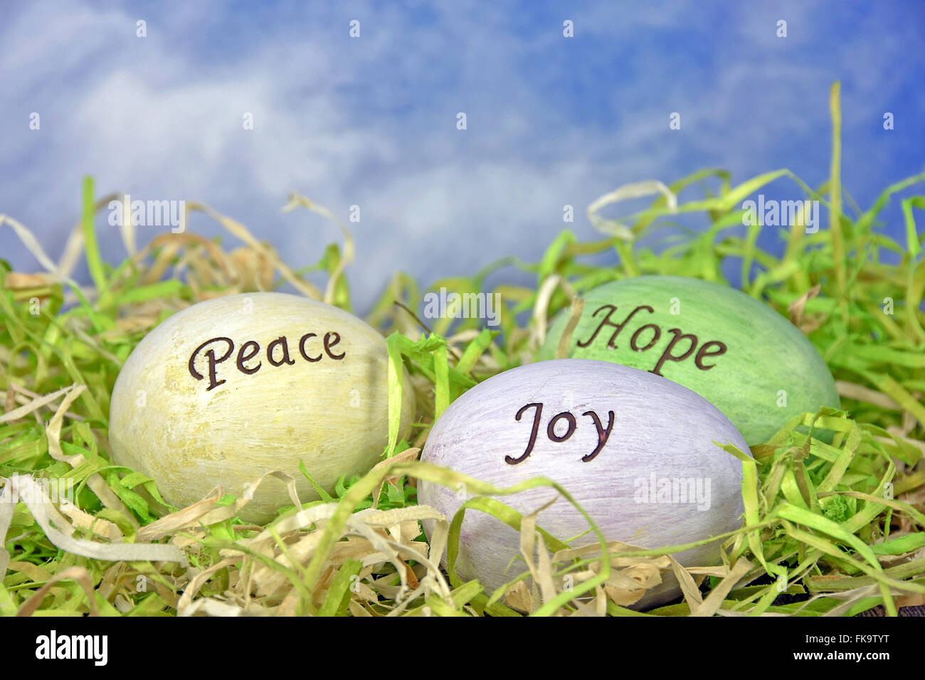 Inspirtational Nachricht auf Ostereier in Grasgrün mit blauem Himmelshintergrund. Stockfoto