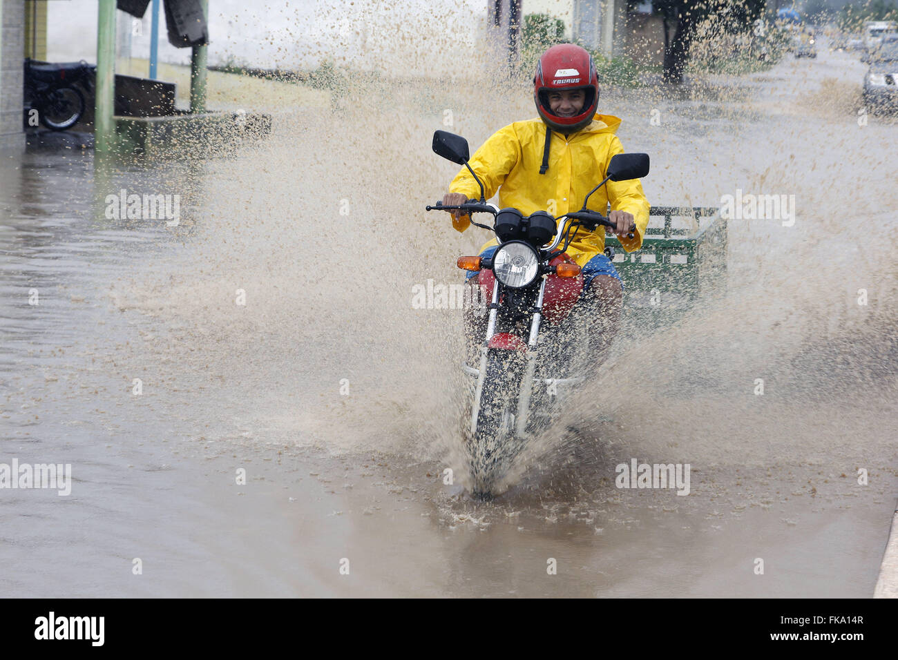 Biker unterwegs auf Straße Abfluss bei Sturm Stockfoto