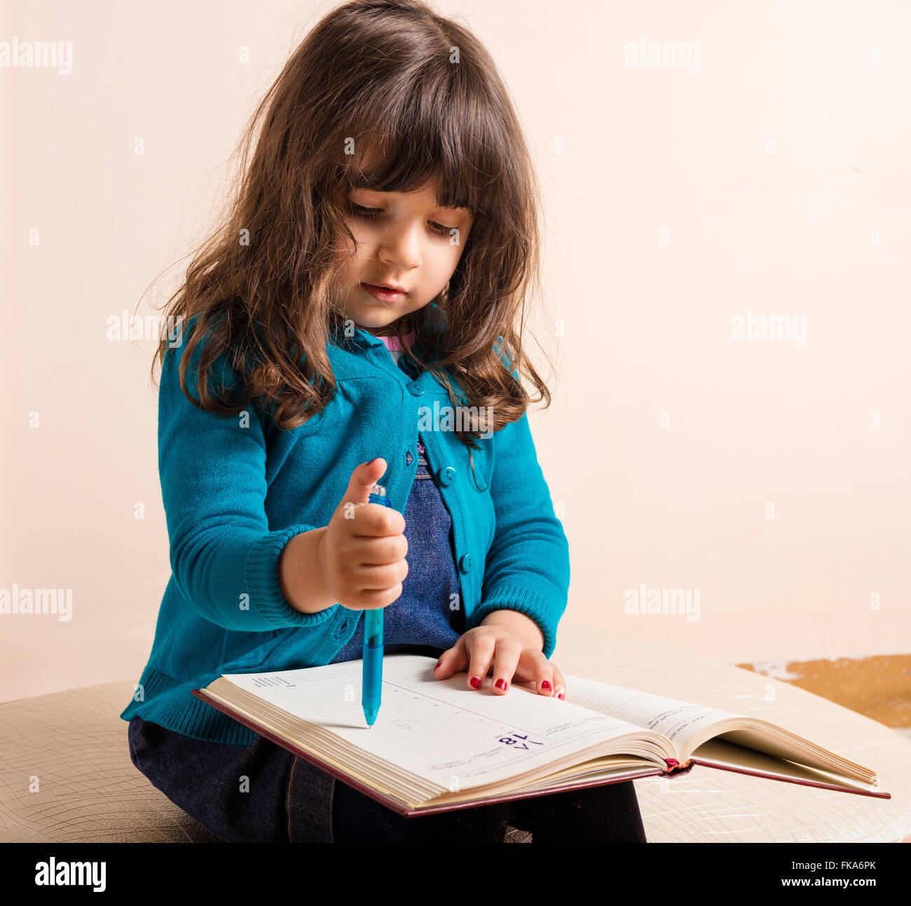 Samll Mädchen in Studio mit roter Interfacemodule und blauen Stift an hand Stockfoto