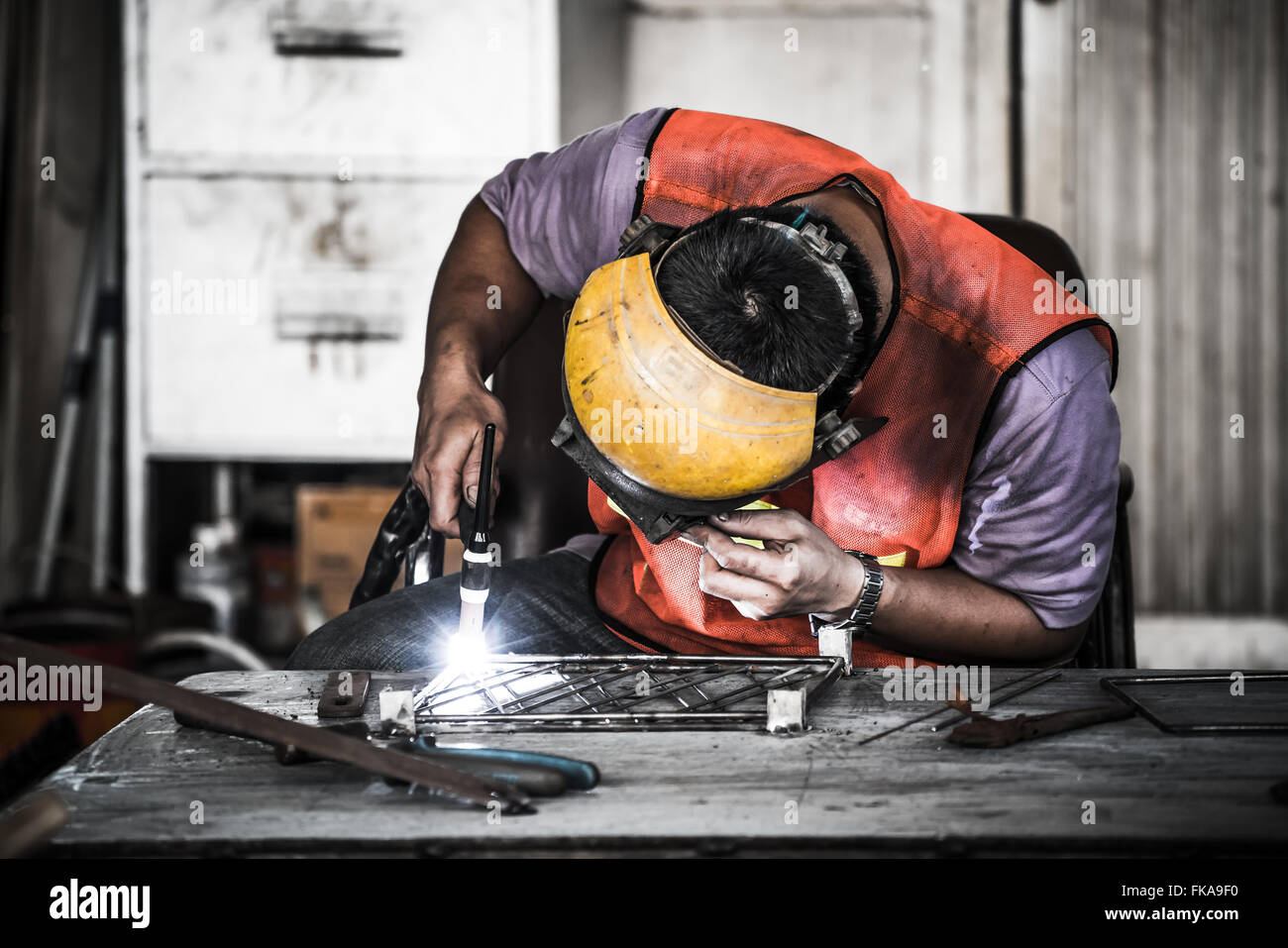 HDR-Bild eines Technikers mit WIG-Schweißer in der Werkshalle Stockfoto