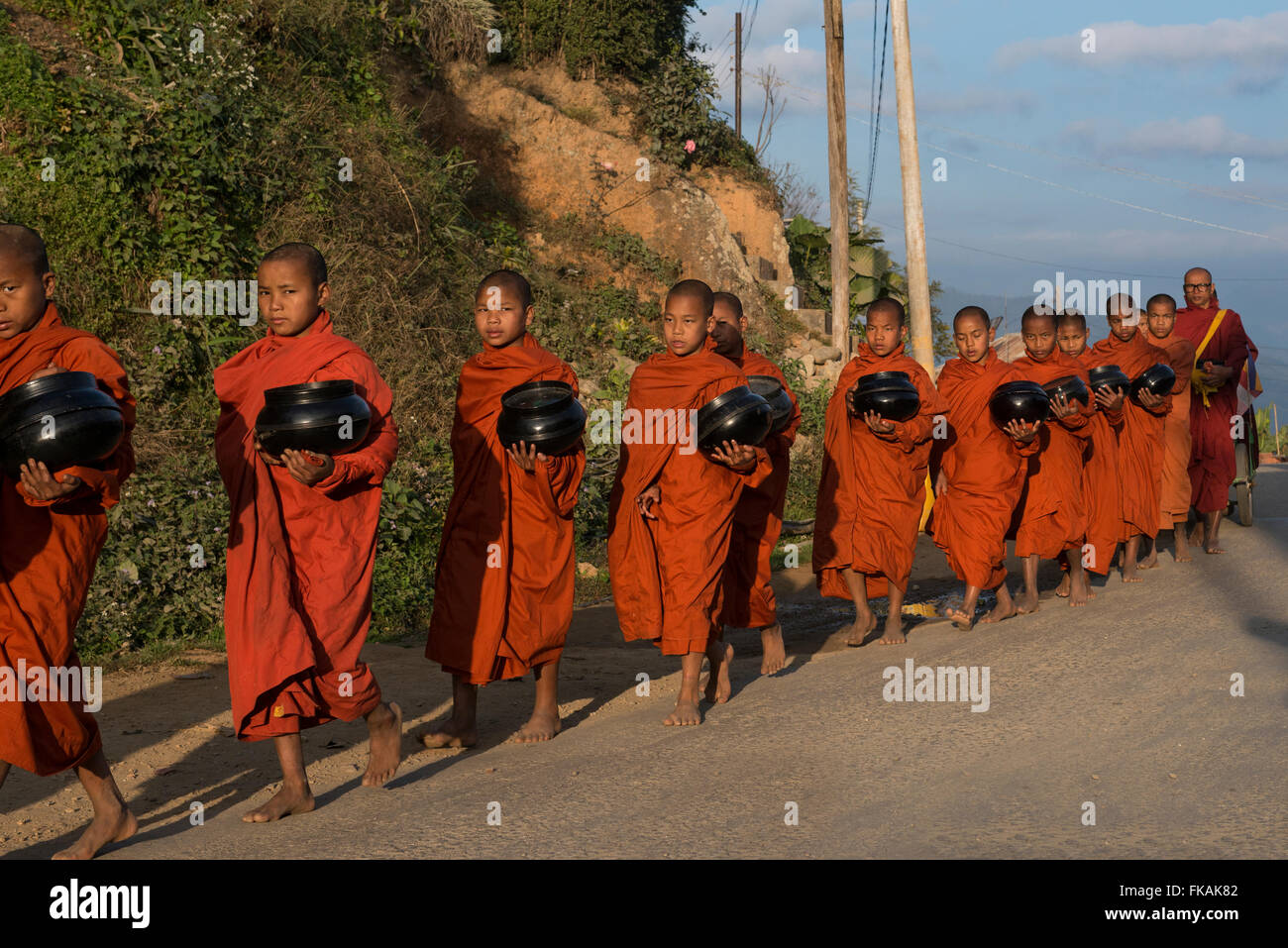 Myanmar, Amarapura, Mahagandayon Kloster, buddhistische Mönche mit Schalen sammeln Lebensmittel-Spende für ihre Mahlzeit Stockfoto