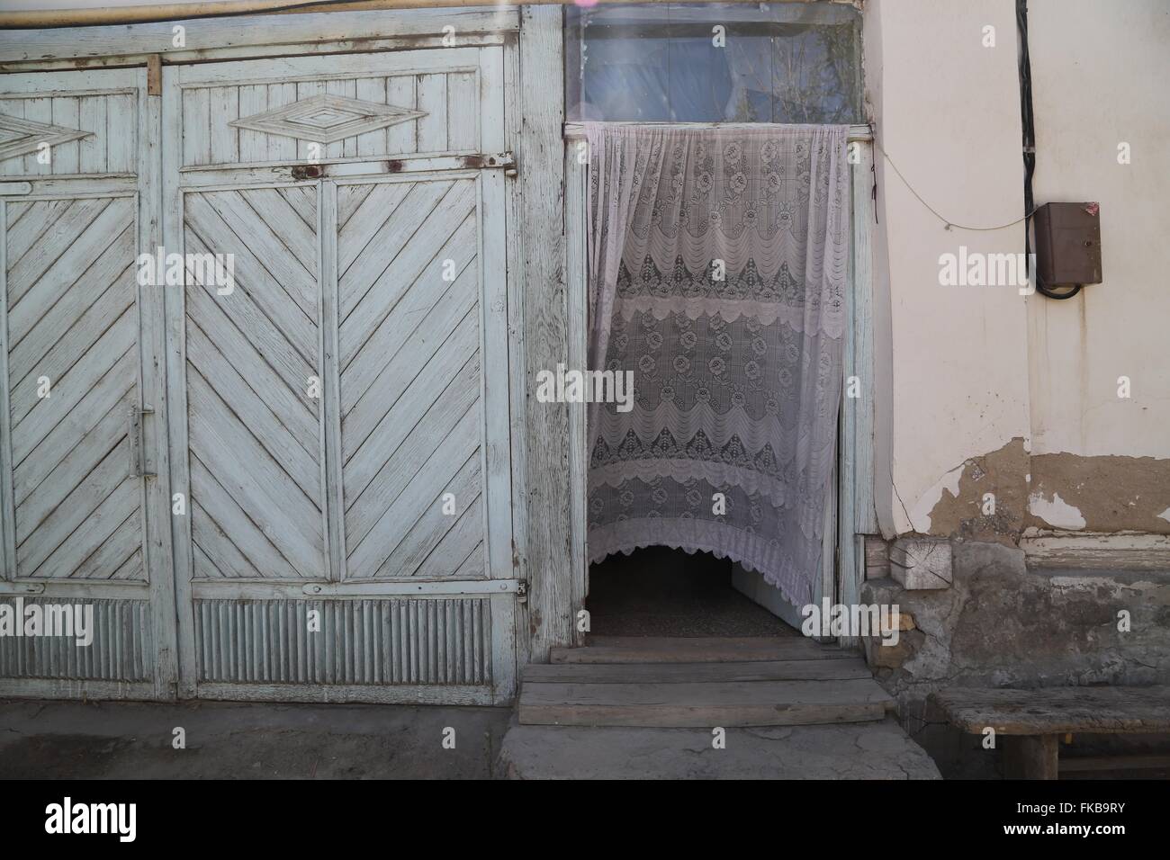 Ein Spitzevorhang bietet Privatsphäre von den Straßen sondern ermöglicht auch Brise an einem heißen Sommertag herein.  Nukus, Usbekistan. Stockfoto