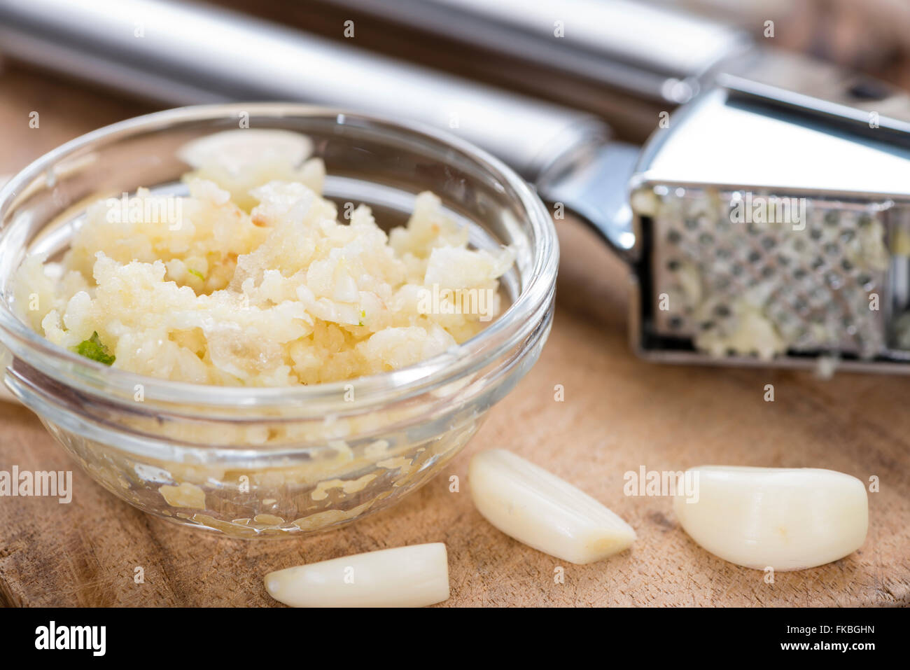 Zerdrückten Knoblauch (Nahaufnahme) auf rustikalen hölzernen Hintergrund Stockfoto