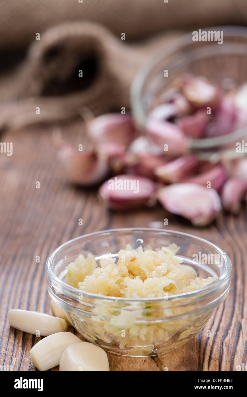 Zerdrückten Knoblauch (Nahaufnahme) auf rustikalen hölzernen Hintergrund Stockfoto