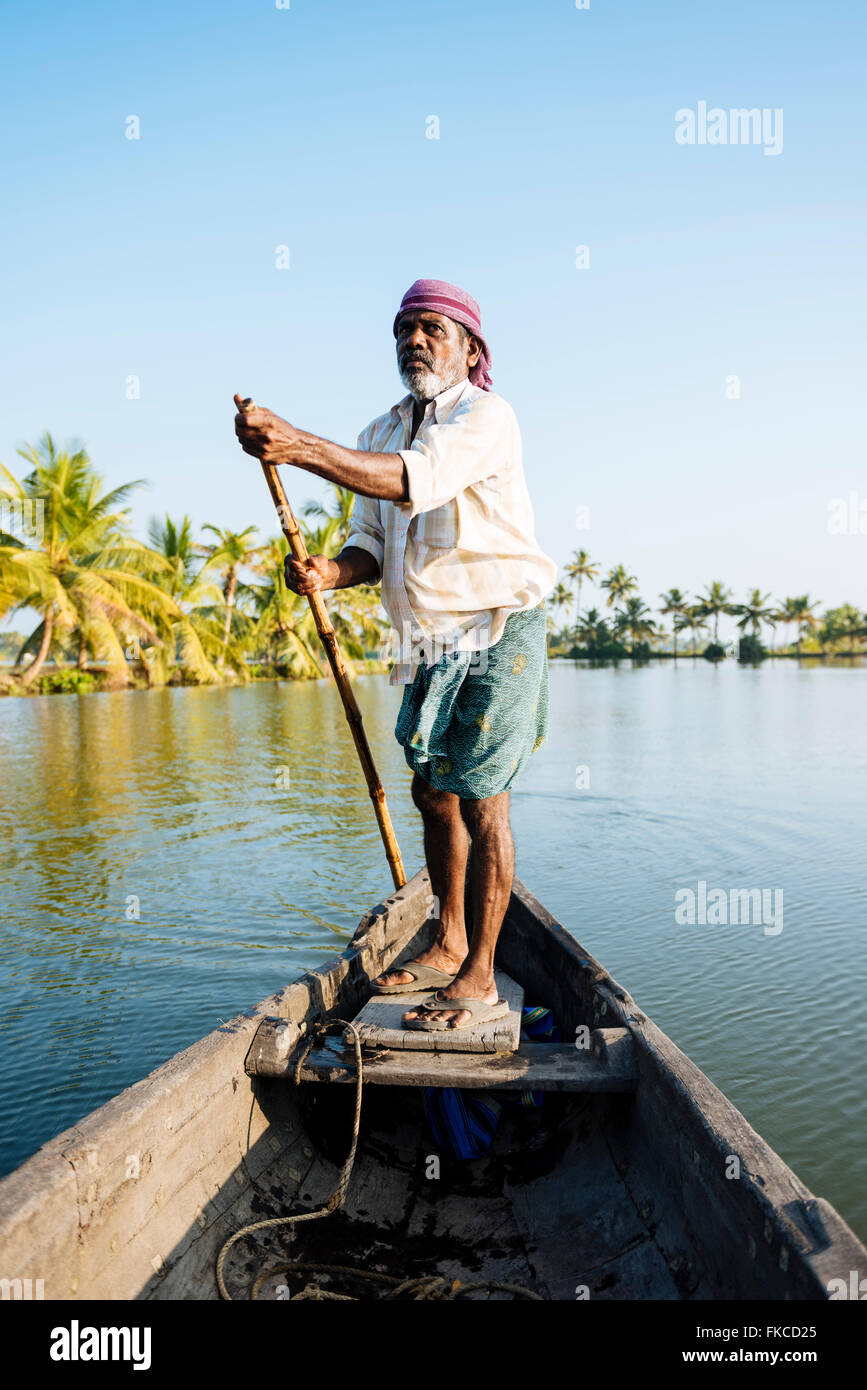 Anthony der Bootsmann Führung des Schiffes durch Keralas Backwaters in der Nähe von North Paravoor, Kerala, Indien Stockfoto