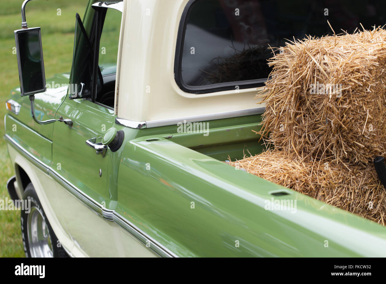 Heuballen auf grüne Pick-up-Truck im Bauernhof laden Stockfoto
