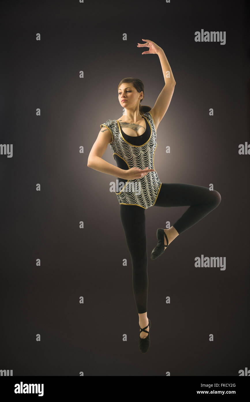 Junge Frau tanzt auf schwarzem Hintergrund Stockfoto