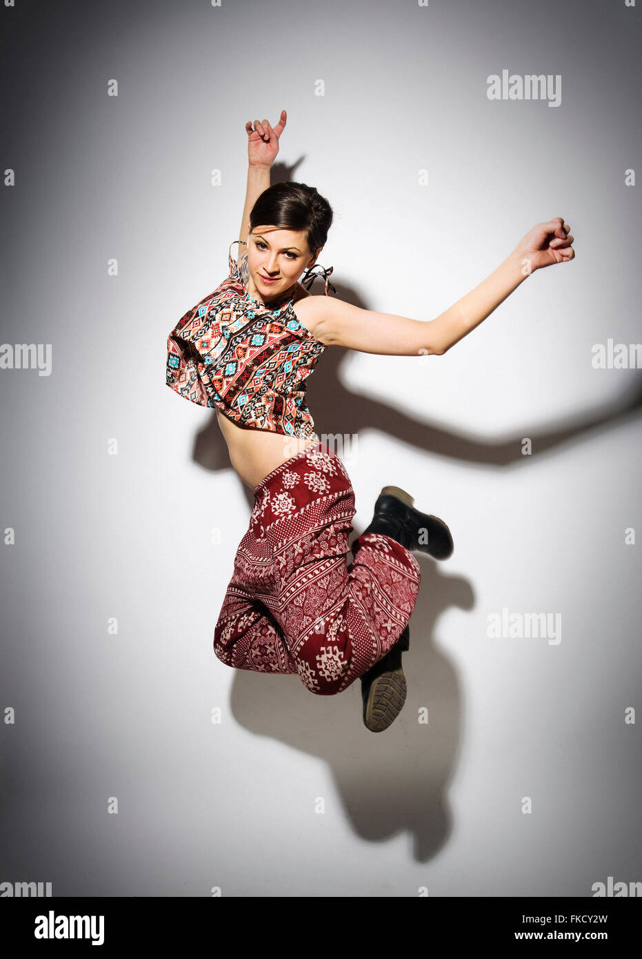 Junge Frau springen vor weißem Hintergrund Stockfoto