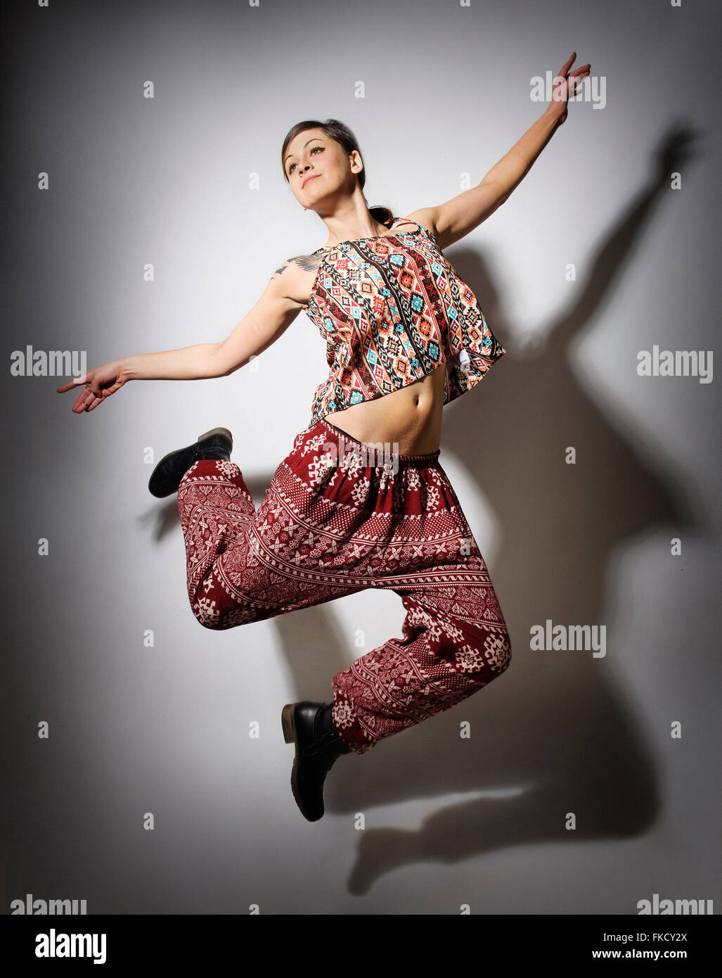 Junge Frau springen vor weißem Hintergrund Stockfoto