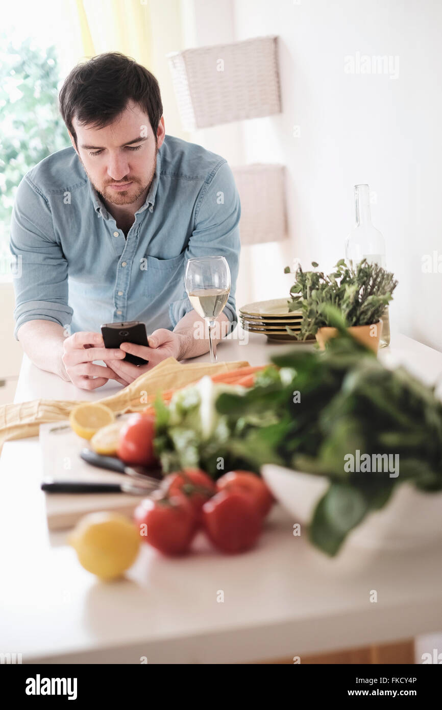 Mann mit Telefon in Küche Stockfoto