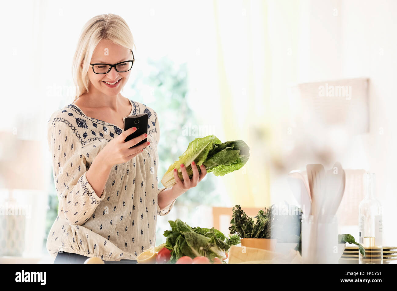 Frau, die Zubereitung von Speisen und Telefon Stockfoto