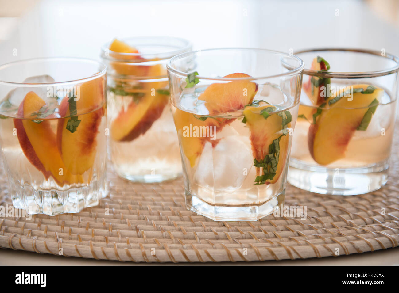 Cocktail mit Scheiben von Pfirsichen im Trinkglas Stockfoto