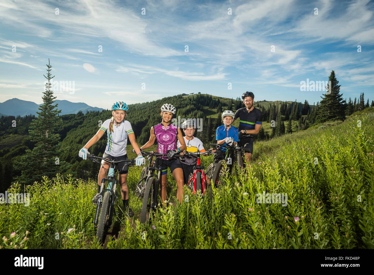 Familie mit Kindern (10-11, 12-13, 14-15) mit Fahrrädern in Berg Stockfoto