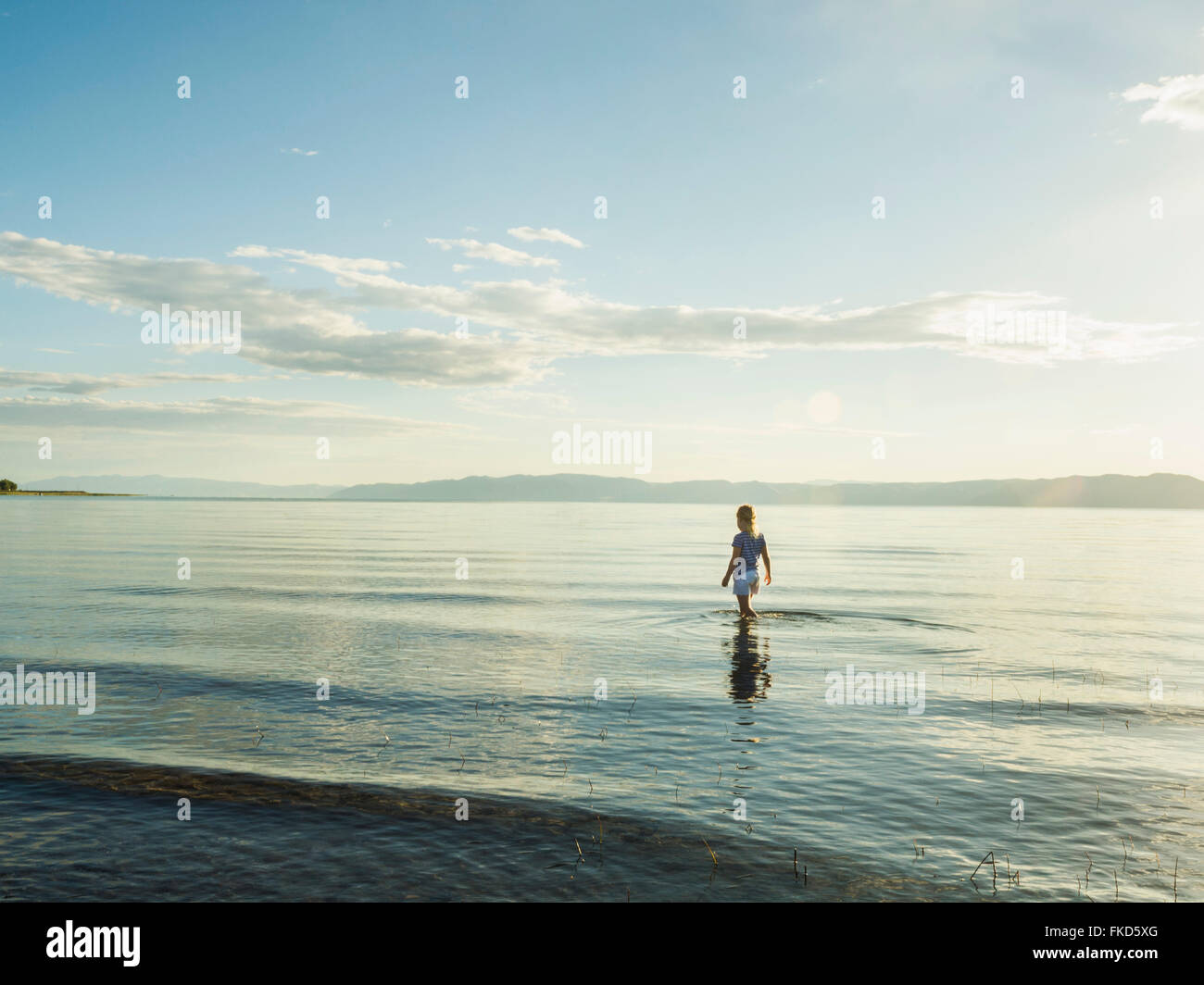 Kleines Mädchen (4-5) waten im See an sonnigen Tag Stockfoto