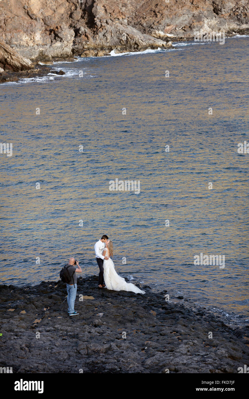 Braut und Bräutigam auf felsigen Strand Teneriffa für Hochzeitsbild nahe dem Ozean Stockfoto