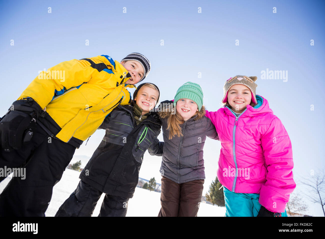 Kinder (8-9, 10-11) stehen im Schnee Stockfoto
