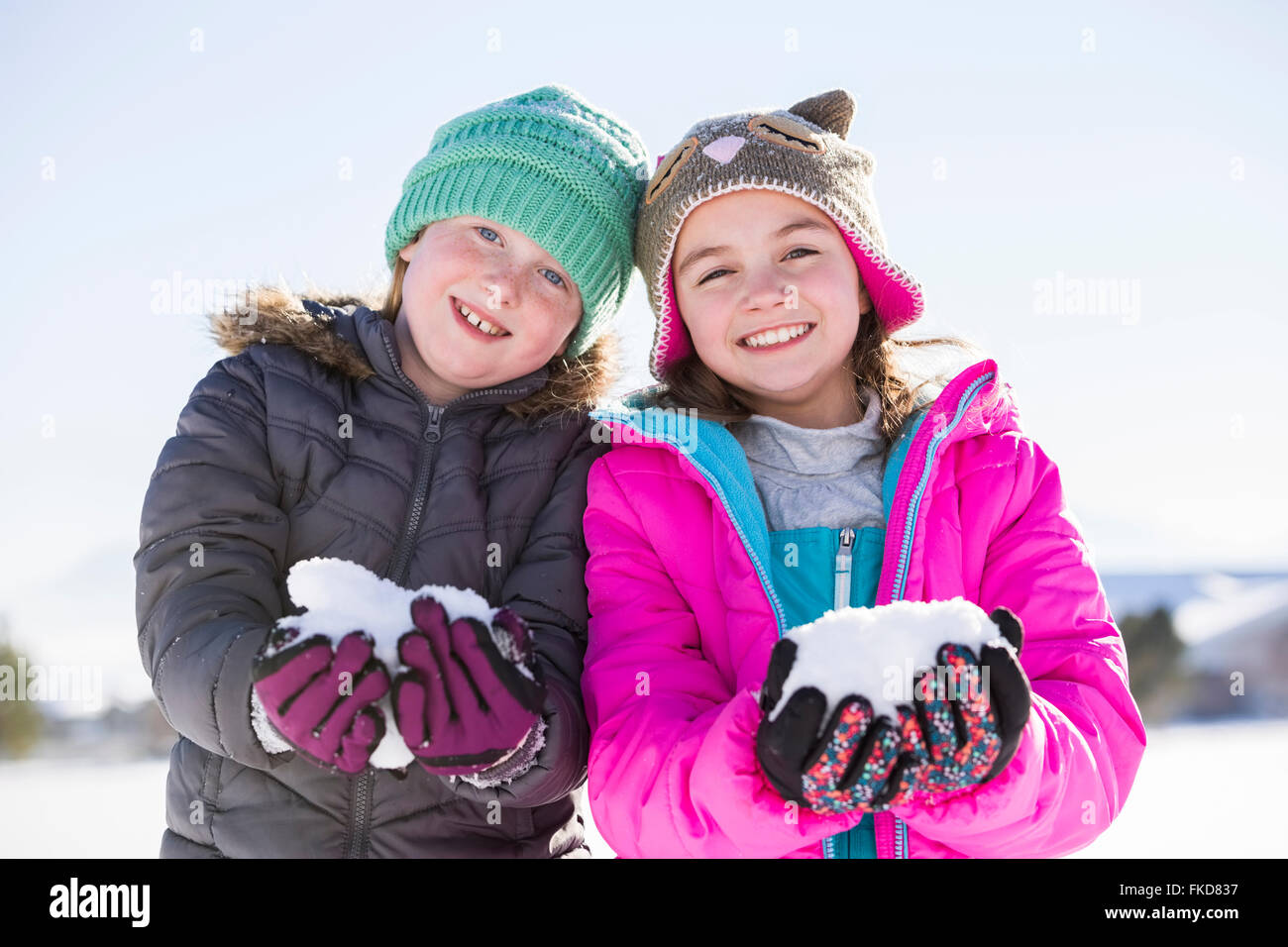 Porträt von Mädchen (8-9, 10-11) halten Schnee Stockfoto