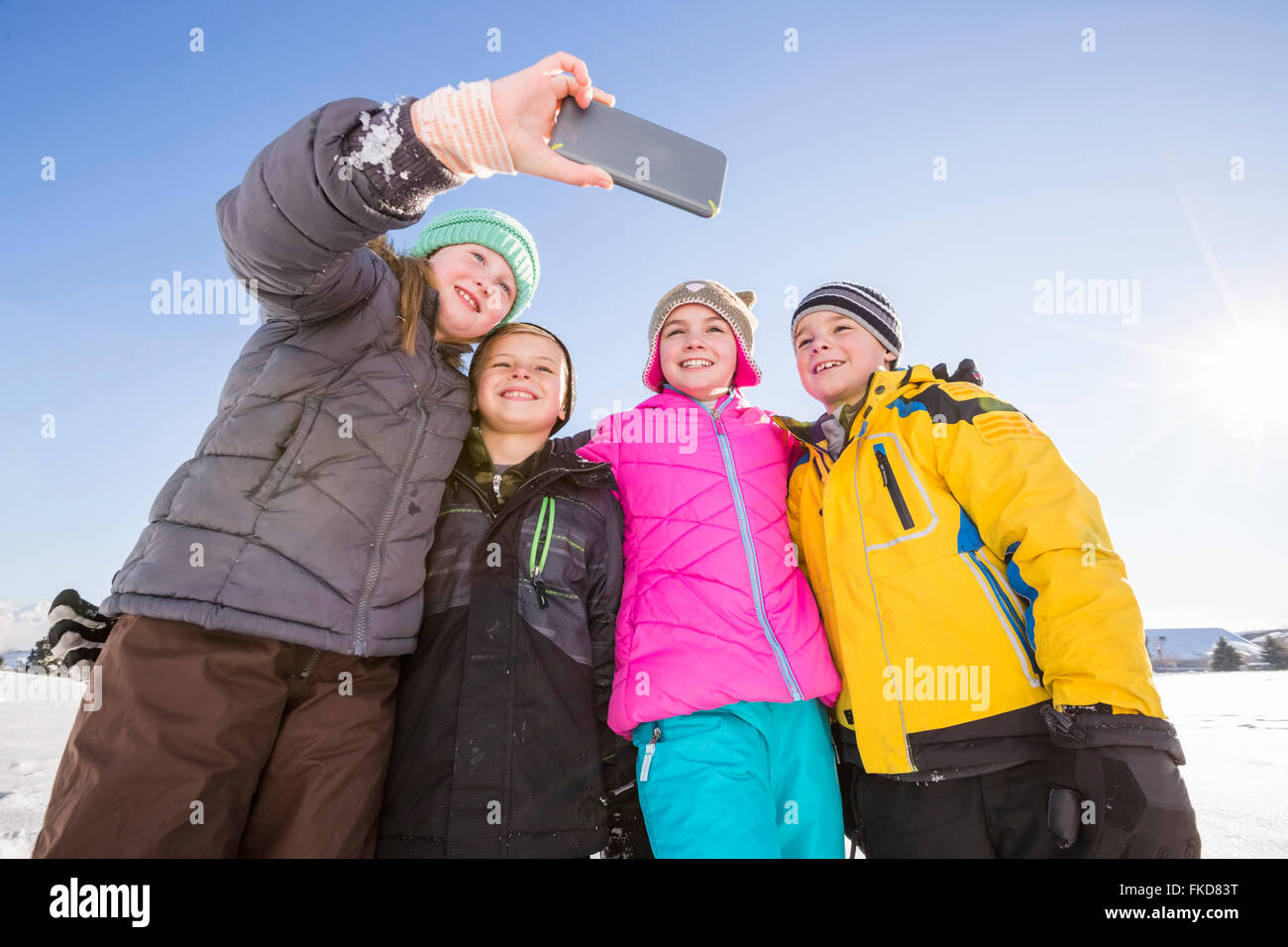 Kinder (8-9, 10-11) nehmen Selfie im winter Stockfoto