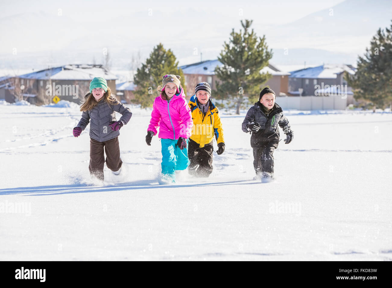 Kinder (8-9, 10-11) laufen im Schnee Stockfoto