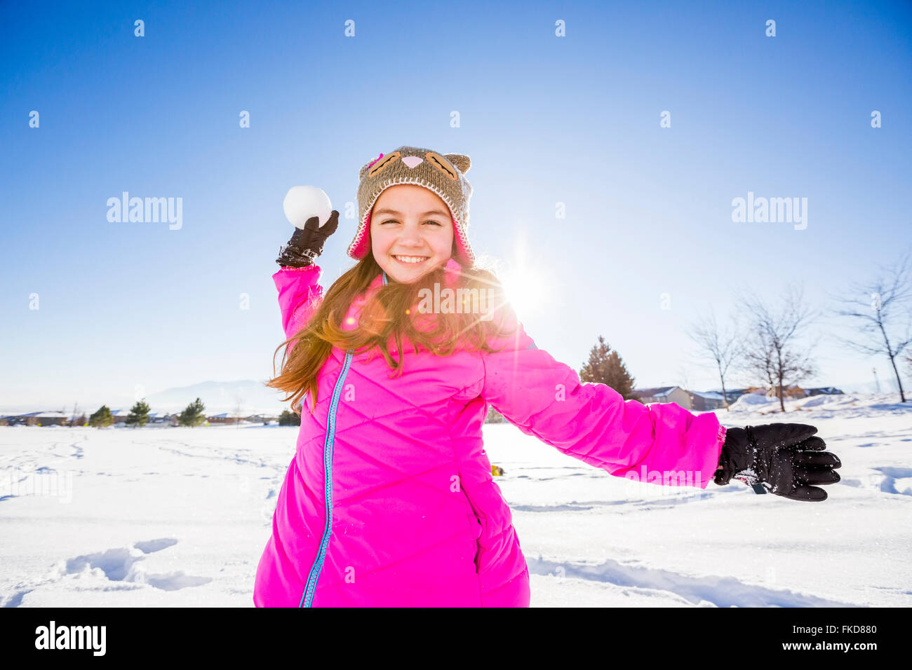 Mädchen (10-11) in rosa Jacke Schneeball werfen Stockfoto
